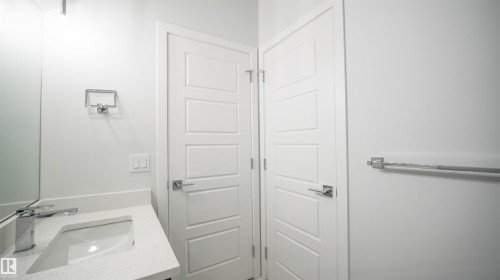 Modern bathroom vanity featuring a rectangular undermount sink, a chrome single-handle faucet, and a light-toned countertop - 44 Dalquist Bay, Leduc, AB 