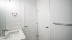 Modern bathroom vanity featuring a rectangular undermount sink, a chrome single-handle faucet, and a light-toned countertop - 
