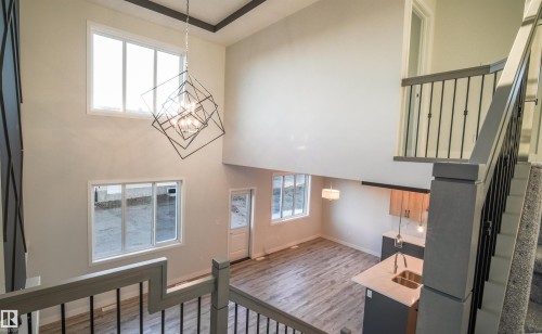 Two-story entryway featuring a multi-tiered geometric chandelier - 44 Dalquist Bay, Leduc, AB 