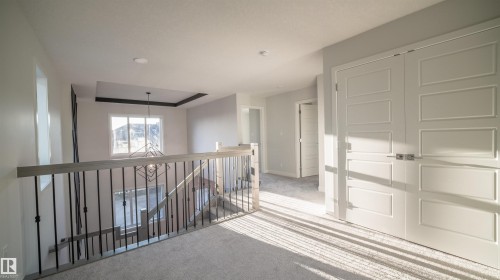 Upper-level hallway with light-toned carpet flooring and paneled doors - 44 Dalquist Bay, Leduc, AB 