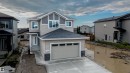 Two-story home with a light beige and dark gray exterior, featuring a double garage and a multi-pane front door - 44 Dalquist Bay, Leduc, AB 