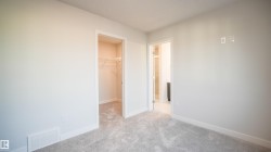 Carpeted interior space featuring light gray walls and white baseboards - 