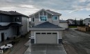 Contemporary two-story residence with a tan siding exterior and a dark grey shingle roof - 44 Dalquist Bay, Leduc, AB 
