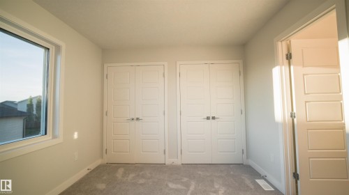 Room featuring light gray carpet, white painted walls, and a white framed window - 44 Dalquist Bay, Leduc, AB 