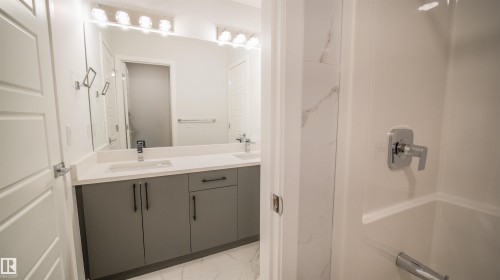 Bathroom featuring a double vanity with gray cabinetry, white countertops, and integrated rectangular sinks - 44 Dalquist Bay, Leduc, AB 