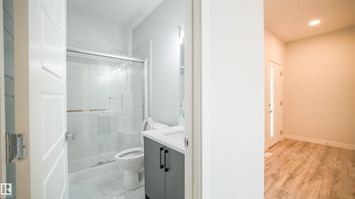 Bathroom featuring a glass-enclosed shower with a sliding door, a modern vanity with dark cabinetry, and a white countertop - 44 Dalquist Bay, Leduc, AB 