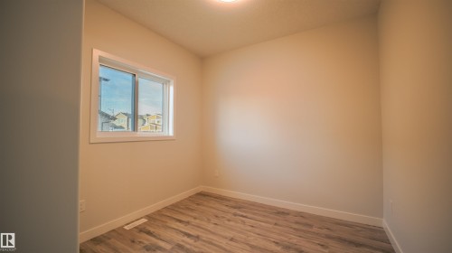 Room featuring light wood-finish flooring, neutral wall tones, and a window with white trim - 44 Dalquist Bay, Leduc, AB 