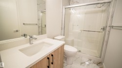 Contemporary bathroom featuring a wood-finish vanity with a white countertop and rectangular undermount sink - 