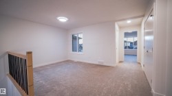 Carpeted landing area featuring a modern wood and metal stair railing, recessed lighting, and a window with exterior views - 