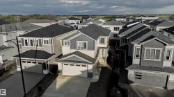 Modern residential exterior featuring a two-car garage, contemporary siding, and dark shingle roofing - 