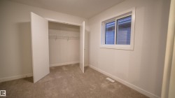 Carpeted room featuring a white-framed window, baseboards, and a closet with bifold doors and wire shelving - 