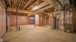 Unfinished basement featuring exposed wood joists, concrete flooring, and insulated walls - 