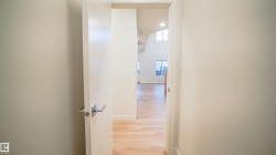 Interior entryway with a modern white door and brushed chrome hardware - 