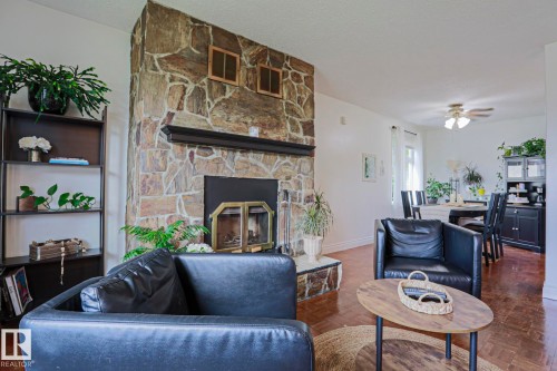 Floor-to-ceiling stone fireplace featuring a black mantel - 2007 67 Street, Edmonton, AB 