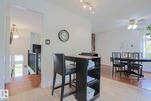Open-concept living area featuring light wood-finish flooring, white walls, and an arched entryway - 2007 67 Street, Edmonton, AB 