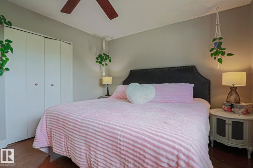 Bedroom featuring neutral wall paint, wood-finish flooring, and a ceiling fan with wood-tone blades - 2007 67 Street, Edmonton, AB 