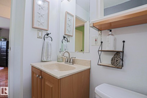 Bathroom vanity with an integrated sink, brushed nickel faucet, and wood-finish cabinetry - 2007 67 Street, Edmonton, AB 