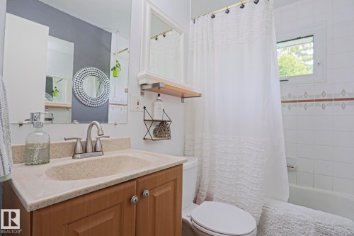 Bathroom featuring a light-toned vanity with an integrated sink and brushed nickel faucet - 2007 67 Street, Edmonton, AB 
