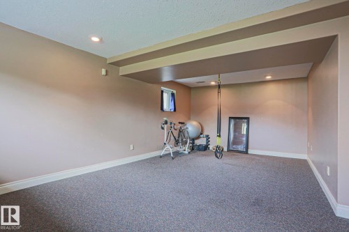 Spacious room featuring neutral painted walls, recessed lighting, and grey carpeting - 2007 67 Street, Edmonton, AB 