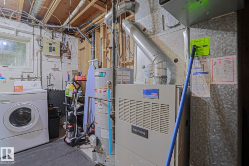 Utility area featuring a water heater, furnace, and exposed ceiling joists - 2007 67 Street, Edmonton, AB 