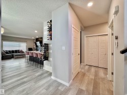Open-concept living space featuring wood-finish flooring, recessed lighting, and a built-in wine rack - 