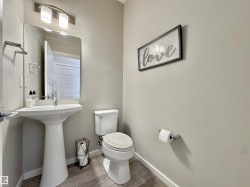 Pedestal sink with chrome faucet, square mirror, and two-light vanity fixture - 