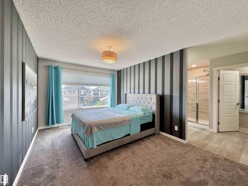 Carpeted bedroom with a window featuring blinds and an overhead light fixture - 302 Balsam Link, Leduc, AB 