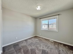 Carpeted room featuring light gray painted walls, a flush-mount ceiling light fixture, a window with white trim, and a window treatment - 