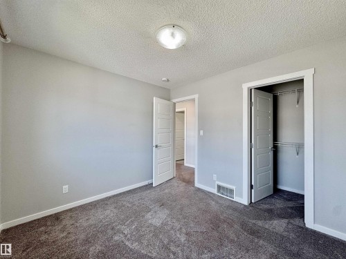 Spacious room with plush gray carpeting, light gray walls, and white trim - 302 Balsam Link, Leduc, AB 