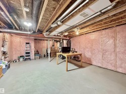 Unfinished basement featuring exposed joists and insulation-ready walls - 