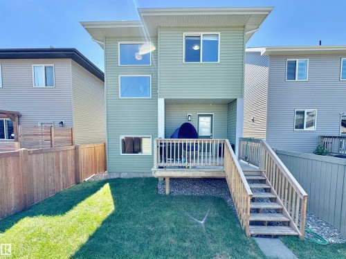 Rear exterior featuring a multi-level design with light green horizontal siding and white trim - 302 Balsam Link, Leduc, AB 