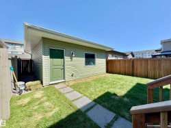 Freestanding accessory structure with a sloped roofline and green horizontal siding - 