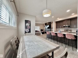 Kitchen featuring dark wood cabinetry, stainless steel appliances, and a light-toned countertop with an integrated sink - 
