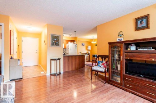Spacious living room with electric fireplace for cozy evenings. - 303 10528 77 Avenue, Edmonton, AB 