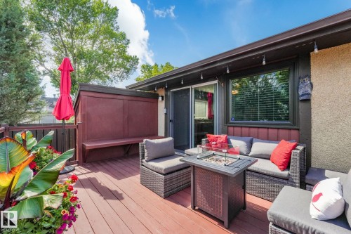 Expansive outdoor deck featuring wood-finish flooring, built-in bench seating, and a sliding glass door for interior access - 17237 104 Street, Edmonton, AB 