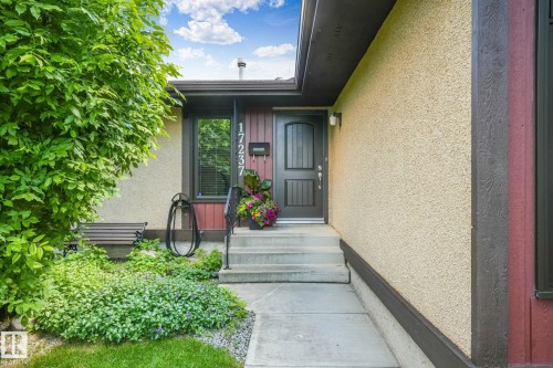 Stucco exterior with dark trim accents and a dark paneled entry door - 17237 104 Street, Edmonton, AB 