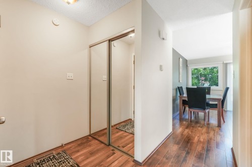 Entryway featuring wood-finish flooring, mirrored sliding closet doors, and recessed ceiling lighting - 17237 104 Street, Edmonton, AB 