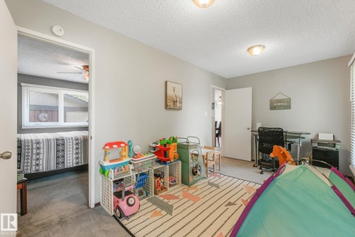 Spacious room featuring neutral-toned walls, textured ceiling, and carpet flooring - 17237 104 Street, Edmonton, AB 