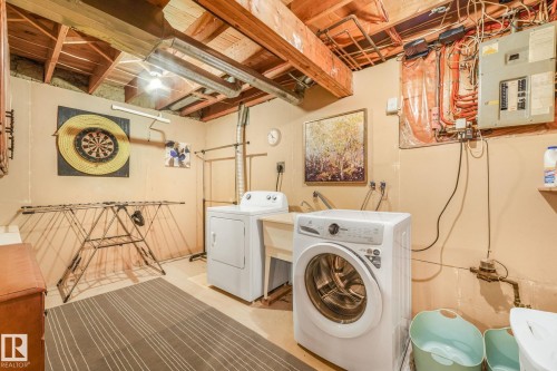 Laundry area featuring a utility sink, exposed ceiling joists, and a concrete floor - 17237 104 Street, Edmonton, AB 