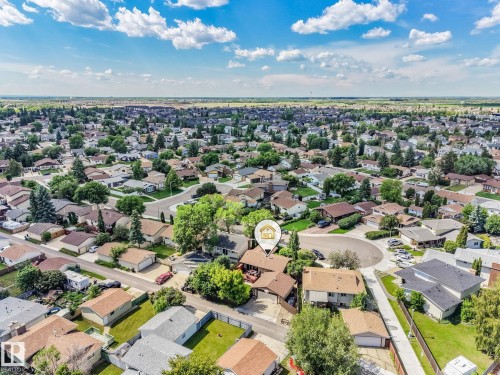 Aerial perspective showcasing a residential neighborhood with numerous detached homes, mature trees, and paved streets - 17237 104 Street, Edmonton, AB 