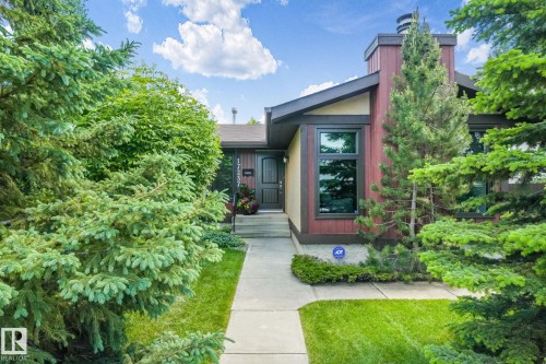 Contemporary facade featuring wood-look siding and trim, a dark entry door, and large rectangular windows - 17237 104 Street, Edmonton, AB 