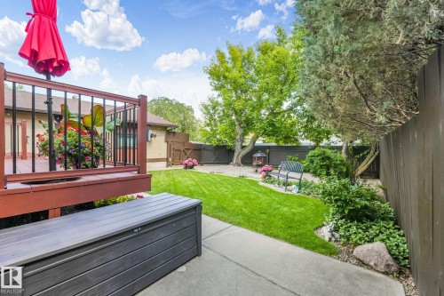 Expansive backyard featuring a manicured lawn, established perimeter landscaping, and mature trees - 17237 104 Street, Edmonton, AB 