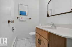 Bathroom vanity featuring a wood-finish cabinet, white countertop with integrated sink, and chrome faucet - 