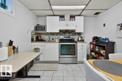 Kitchen featuring white cabinetry, stainless steel range, and mosaic tile backsplash - 