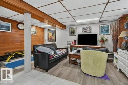 Spacious multi-purpose room featuring wood-finish flooring, wood paneling, and a drop ceiling with recessed lighting - 