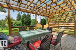 Expansive outdoor patio featuring a wood pergola with a translucent roof, a wood privacy screen, and a patterned paver stone surface - 