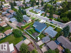 Aerial perspective showcasing residential properties with varying roof styles and exterior finishes - 
