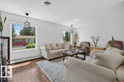 Spacious interior featuring wood-finish flooring, white walls, and a large window providing ample natural light - 