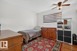 Bright room featuring a ceiling fan with integrated lighting, a window with horizontal blinds, and wood-finish flooring - 
