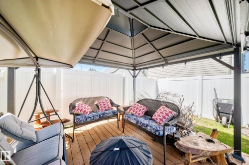 Expansive outdoor decking featuring a partial overhead covering, privacy fencing, and a built-in metal gazebo structure - 12410 171A Avenue, Edmonton, AB 